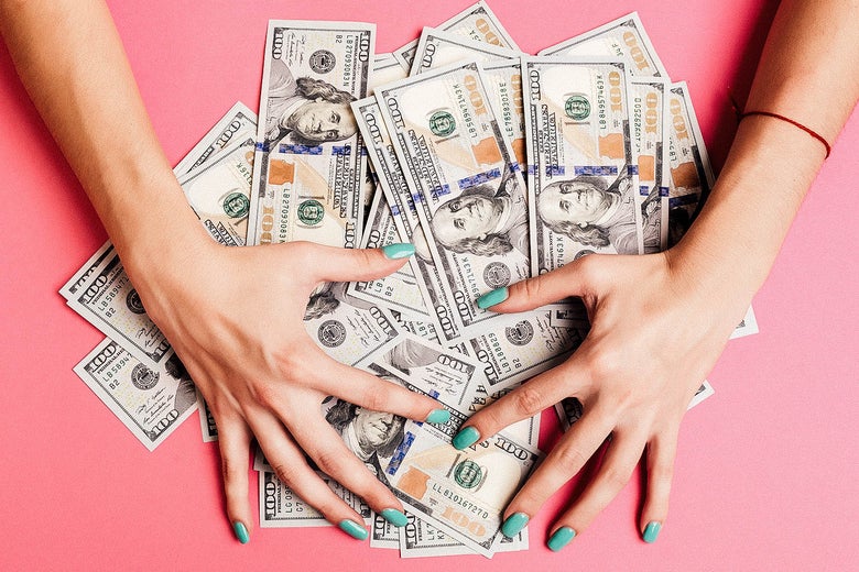 Women with scattered pile of money on table.